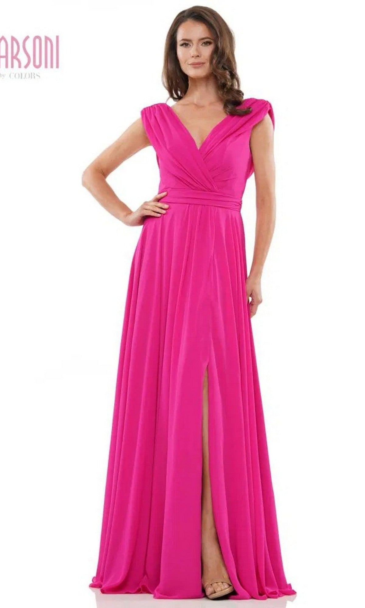 A woman models the Marsoni M251 Long Formal Dress in fuchsia—a floor-length chiffon gown with a V-neckline, cap sleeves, gathered waist, and front slit—posing against a plain white background.